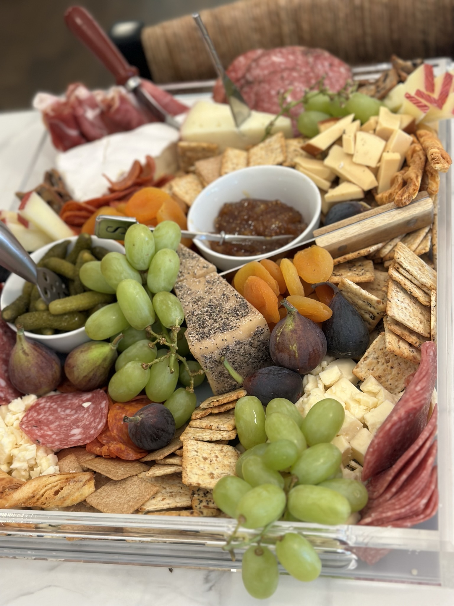 Charcuterie board with artisan meats, cheeses, grapes, and figs