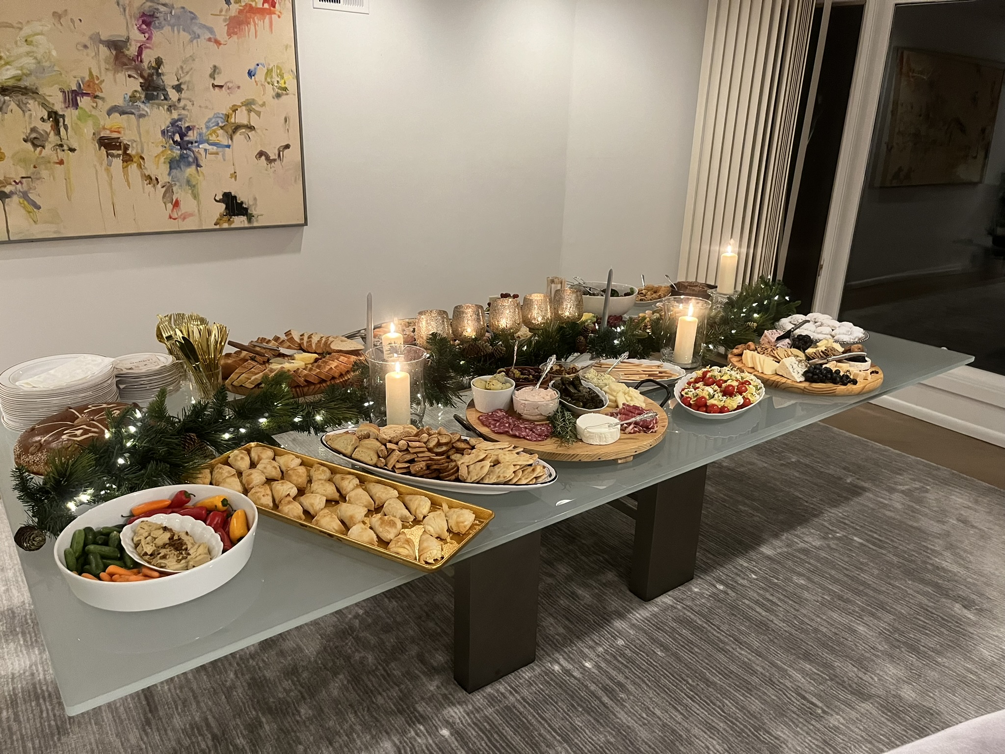 Holiday dessert spread with pastries, candles, and festive greenery